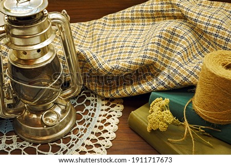   Checkered cloth,two books,a coil of twine,dried flowers, a kerosene lamp, an openwork napkin.                             