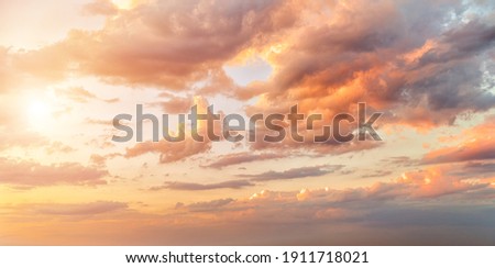 Beautiful sunset or sunrise sky with clouds and sun in the frame, background Royalty-Free Stock Photo #1911718021