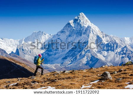 Woman Traveler hiking in Himalaya mountains with mount Everest, Earth's highest mountain. Travel sport lifestyle concept. Ama Dablam mountain view Royalty-Free Stock Photo #1911722092