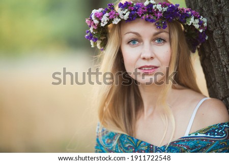 A blonde girl in a flower chaplet in spring time