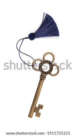 Old golden key with blue tassel isolated on white background