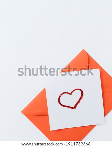 The composition is a red heart and an envelope on a white background.flat lay.copy space. Love, friendship, and a declaration of love.Happy Valentine's Day.Women's Day.Minimal, stylish holiday concept
