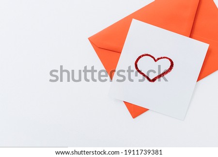 The composition is a red heart and an envelope on a white background.flat lay.copy space. Love, friendship, and a declaration of love.Happy Valentine's Day.Women's Day.Minimal, stylish holiday concept
