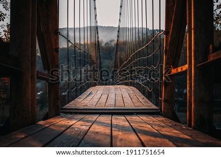 Suspension bridge, Crossing the river, ferriage in the woods, autumn forest Royalty-Free Stock Photo #1911751654
