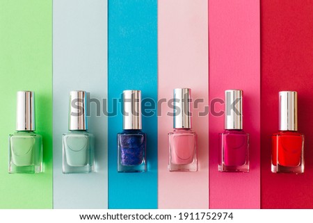 Bottles of colorful nail polish on colorful background. Manicure and pedicure concept. Flat lay, top view, copy space. Royalty-Free Stock Photo #1911752974