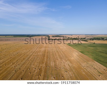 Landscape view from drone, yellow and green fields and haystacks