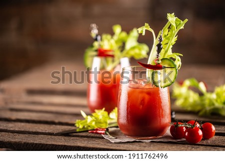 Bloody or virgin mary cocktail served in a cup with celery sticks and cherry tomatoes. Royalty-Free Stock Photo #1911762496