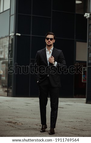 A shallow focus shot of a handsome Caucasian businessman in sunglasses posing for the camera