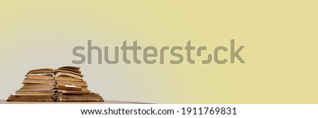 there are many old open books with bookmarks on a wooden table, on a yellow background.Banner. High quality photo