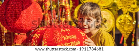 BANNER, LONG FORMAT Caucasian tourist boy in Tet holidays. Vietnam Chinese Lunar New Year in springtime. TEXT TRANSLATION from Vietnamese: Congratulations on the Vietnamese, Chinese New Years and