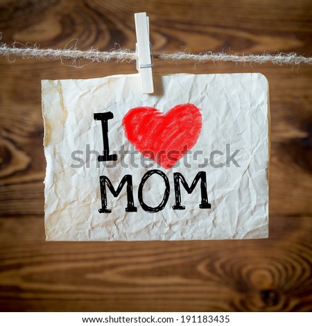 Text I love mom on the old paper and clothes peg wood background