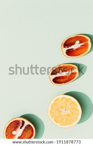 Bright slices citrus fruits, grapefruit, orange on pastel colored background. Fruit food and summer concept. Top view with sunlight.