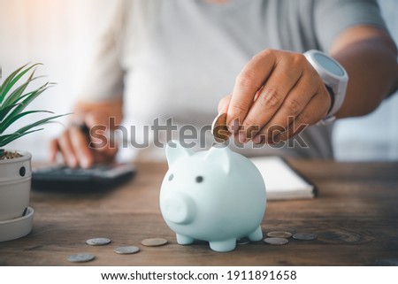 Hand holding coin with pig piggy bank. Saving and financial accounts concept	 Royalty-Free Stock Photo #1911891658
