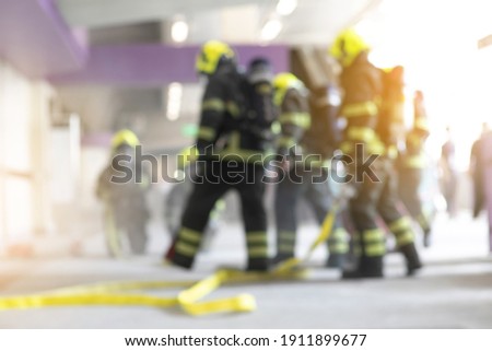 blurred firefighters training spraying water to fire