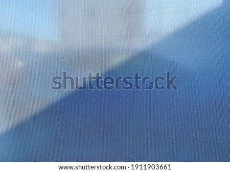 Light an shadows on the white plastic curtain with blurred background