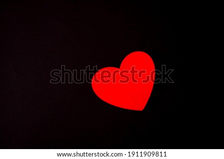Red heart lie on a black background
