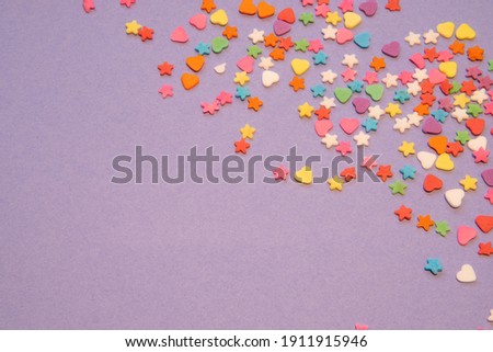Small colorful candies, Heart and star shapes, on a purple background. Valentine day. About love. copy space. High quality photo
