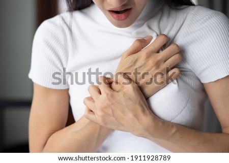 woman with sudden heart attack, sick woman suffering from acute heart attack, concept of emergency health care, asian young adult woman model Royalty-Free Stock Photo #1911928789