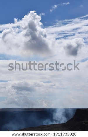 Volcanic steam floating up to fluffy white clouds. Scenic Mount Kilauea on Big Island, Hawaii