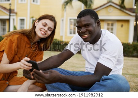 cheerful young couple outdoors with a phone in hands communication