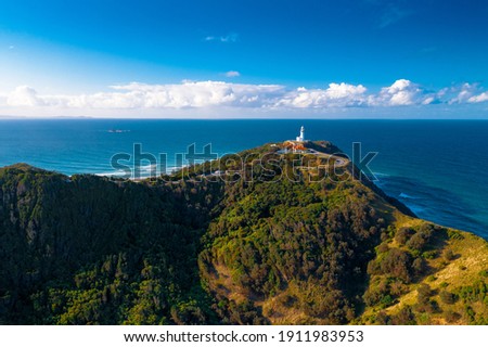 Stunning View Byron Bay Lighthouse Sunny Day Waves Crashing Blue Ocean Trees Small Hill Rocky Break Colourful Photograph Royalty-Free Stock Photo #1911983953
