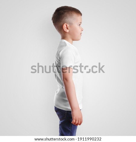 Mockup of children's casual t-shirt on a boy, side view, isolated on background. Template of fashionable clothes for junior, for design presentation, advertising in an online store. Textured kidswear