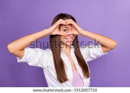 Photo of funny playful flirty girl fingers show heart figure hide eye wear white shirt isolated purple color background
