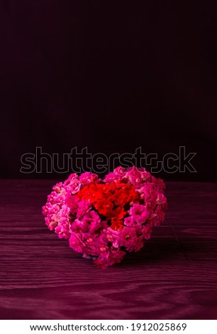 A big heart made of fresh flowers. composition of flowers. Valentine's Day. red hearts on black isolated background beautiful holiday card