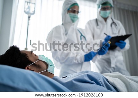 Caucasian doctor, nurse or scientist diagnosis patient symptom on bed for analysis the drug, medicine, vaccination and preparing for injection to patient in hospital. Covid19 medicine and drug concept Royalty-Free Stock Photo #1912026100
