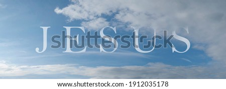 Abstract religious concept. Name of Jesus written on the blue sky with some clouds and sunlight. Royalty-Free Stock Photo #1912035178