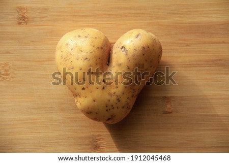 special potato from organic farming, heart-shaped, on a bamboo wood background.