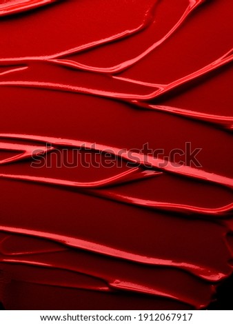 Cosmetic background of red smudged lipstick