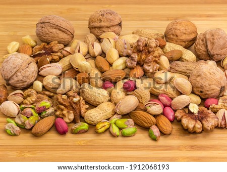 Pile of the various peeled nuts and nuts in their shells on a bamboo wooden surface
 Royalty-Free Stock Photo #1912068193