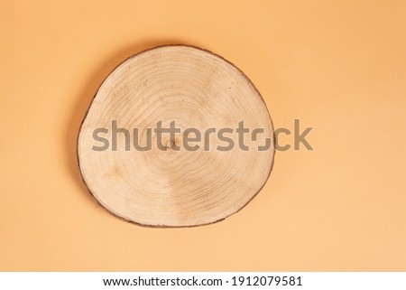 Natural organic eco-friendly beauty product concept. Wooden cross section cut on beige background. Showcase for cosmetic products. Top view, mockup. Product advertisement. wood slice Royalty-Free Stock Photo #1912079581