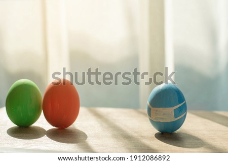 Easter eggs wearing mask for Easter holidays. prevention of coronavirus or covid-19, Easter eggs wearing mask on table with copyspace.