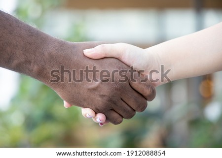 white people and black people hand shaking to each other, concept of skin color tolerance, people inclusivity, ethnic diversity, world peace, ethnicity understanding, team or teamwork