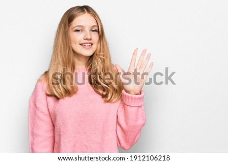 Beautiful young caucasian girl wearing casual winter sweater showing and pointing up with fingers number five while smiling confident and happy. 