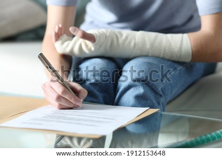 Close up portrait of a disabled woman with bandaged arm sigining insurance document