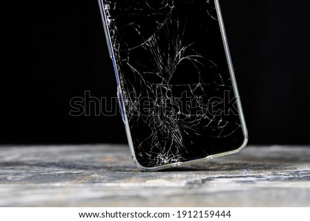 Mobile cellphone with broken glass. Smartphone falling down on the ground and broke touchscreen with beauty dark background