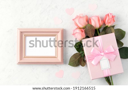 Giftbox and pink rose flower on marble white table background for Valentine's Day holiday greeting design concept.