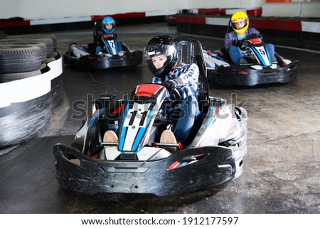 positive people driving sport cars for karting in a circuit lap in sport club Royalty-Free Stock Photo #1912177597