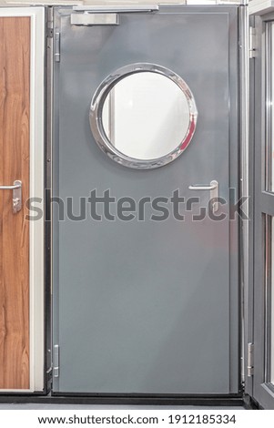 Round Window at Metal Door With Automatic Closer