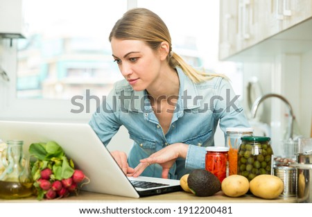 Young woman cooking recipe from the Internet. High quality photo