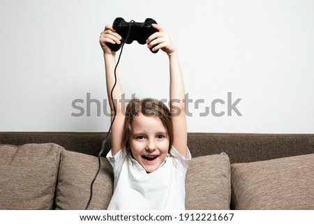 Girl plays on the console, close-up portrait