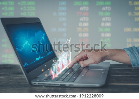 Young money businessman sitting staring at a computer screen displaying a crypto currency featuring stock tickers or graphs. Stock trading platform concept. professional financial advisor. Royalty-Free Stock Photo #1912228009