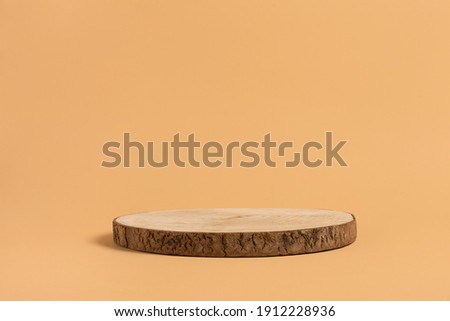 Round wooden saw cut cylinder shape for product presentation on a beige background. Round geometric shape of the cylinder. eco style and minimalism. wood slice Royalty-Free Stock Photo #1912228936