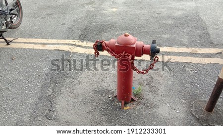 Photo show a red fire hydrant on the road at the city. 