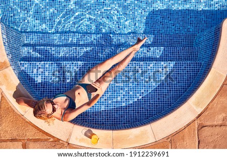 Overhead Shot Of Woman In Bikini Taking Selfie In Outdoor Swimming Pool With Soft Drink