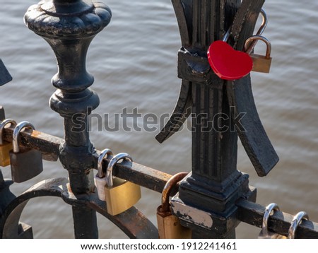 Heart-shaped padlock with some more chained padlocks on the Lover's Bridge in Prague, above Devil's Channel