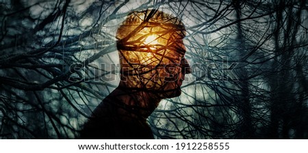 Head of a man on background of trees in forest. Concept on topic of psychology, psychiatry, depression. Branches of trees symbolise problems and diseases, and the sun is a symbol of hope and recovery. Royalty-Free Stock Photo #1912258555